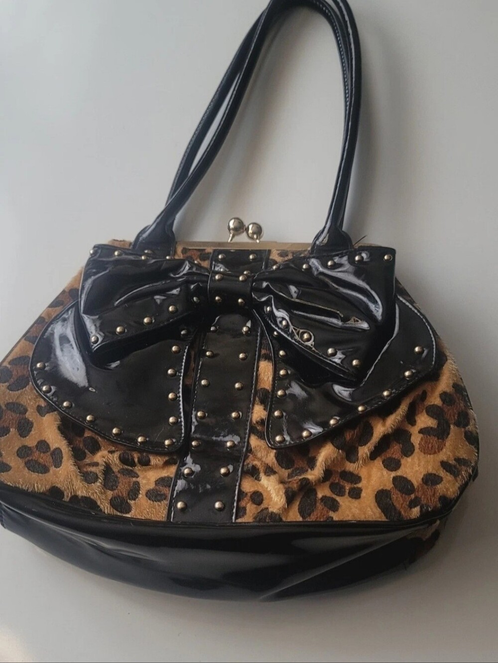 This is a Charming Charlie handbag featuring a textured cheetah animal print.